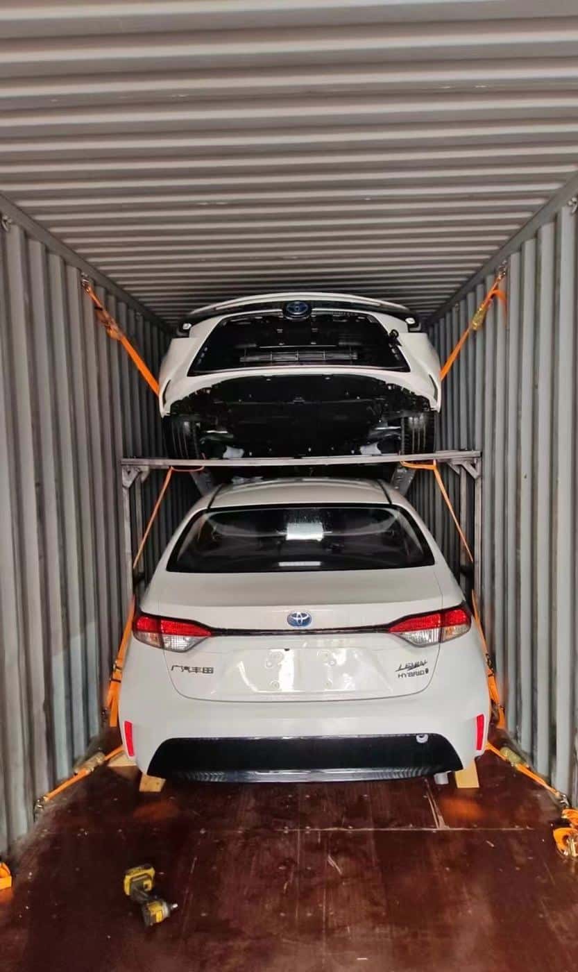 Sedans secured on racks inside a container